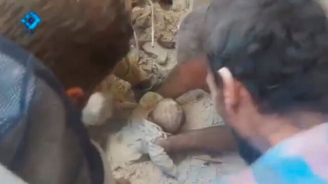 Un bebé es rescatado de entre los escombros de un edificio destruido por los bombardeos