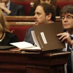 El presidente de la Generalitat, Carles Puigdemont, ordena unos apuntes hoy durante la sesión de control en el Parlament de Cataluña