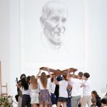 Unos jóvenes portan una cruz en la misa de apertura de la JMJ en Cracovia
