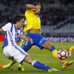El delantero de la Real Sociedad, Mikel Oyarzabal (i), golpea el balón ante el defensa de la UD Las Palmas
