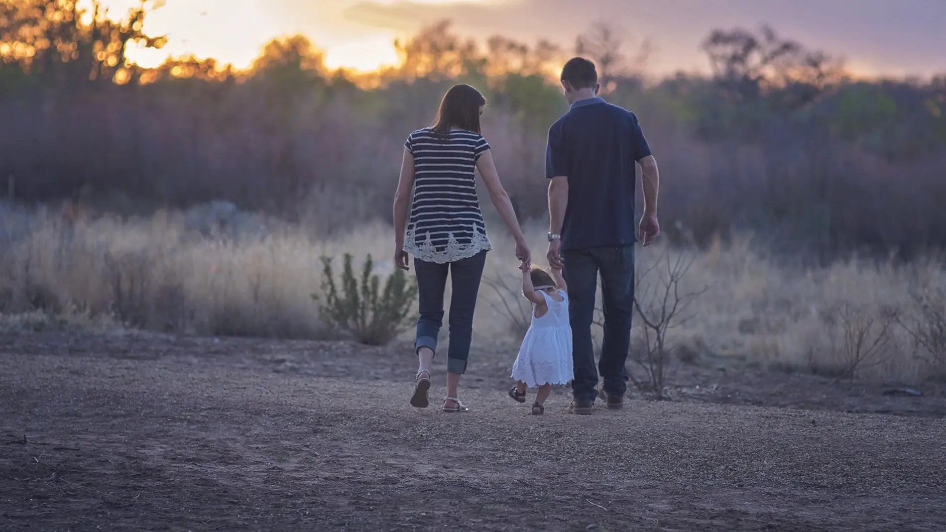 Unos padres pasean con su hija por el campo