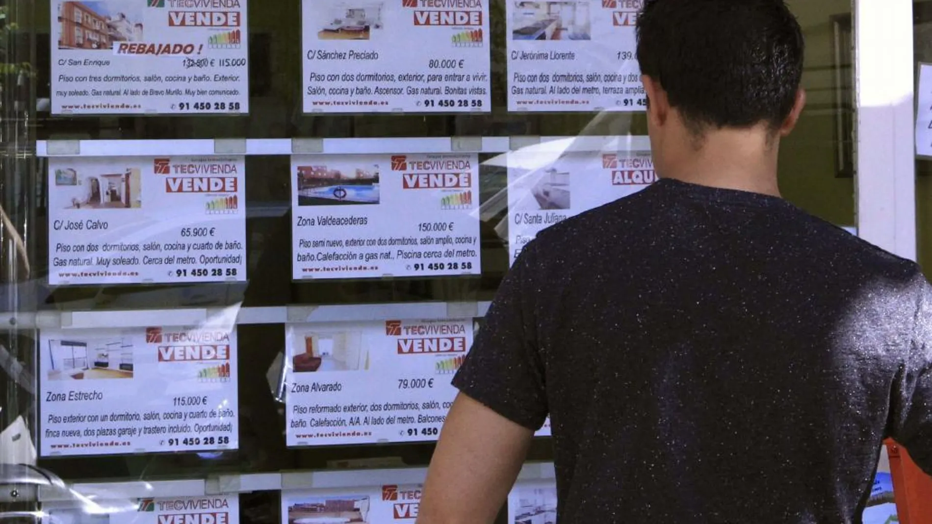 Vista de un escaparate de una inmobiliaria, con anuncios de pisos en venta.