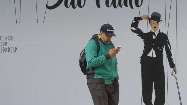 Un joven consulta su teléfono móvil en Sao Paulo
