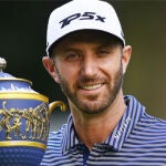 Dustin Johnson posa con el trofeo
