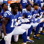 Los jugadores del Indianapolis Colts escuchan, rodilla en tierra, el himno
