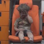 Un niño herido de 5 años sentado en una ambulancia tras ser rescatado anoche de una vivienda bombardeada en Alepo