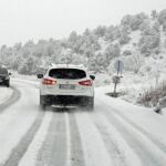Imagen de archivo de un coche circulando por una carretera con nieve 