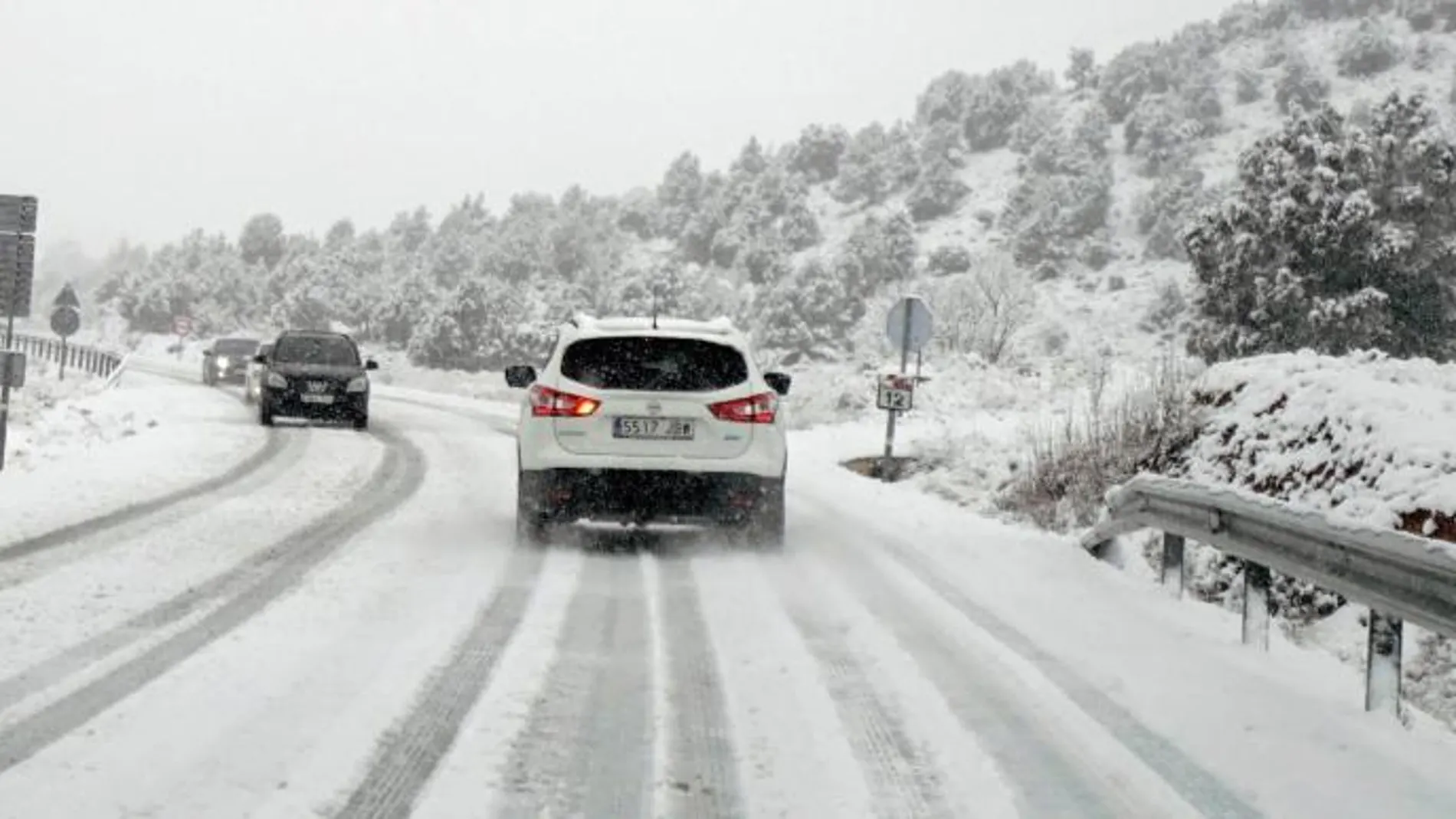 Imagen de archivo de un coche circulando por una carretera con nieve