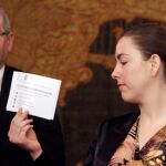 El alcalde de Alicante, Luis Barcala, saluda a Eva Montesinos tras la votación. En la otra gráfica, la tránsfuga Belmonte muestra su voto al hemiciclo