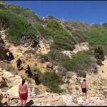 Un grupo de inmigrantes desembarca en una playa de Tarifa ante los sorprendidos turistas