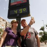 Turistas se hacen una foto este miércoles junto a un termómetro de Córdoba que marca 49ºC / Efe