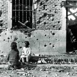 Fotografía de Robert Capa de la casa de la calle Peironcely 10 en la que se observan los restos de metralla en la fachada