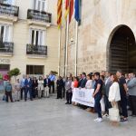Los diputados de Vox (a la izquierda de la imagen) no compartieron la pancarta con el resto de diputados de Les Corts y se matuvieron a un lado durante el minuto de silencio que sí secundaron