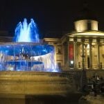 Vista de las fuentes de la Plaza Trafalgar iluminadas de azul para celebrar el nacimiento del hijo del duque y la duquesa de Cambridge, en frente del Palacio de Buckingham