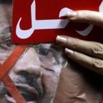 Un detractor de Mursi muesta una tarjeta roja en la que insta al presidente egipcio a marcharse