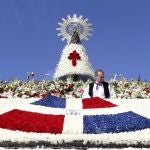 Una ofrenda de flores con la bandera de Santo Domingo destaca sobre el tradicional y colorido manto de la Vírgen del Pilar