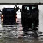 Una persona intenta salir de una furgoneta atrapada en un tunel de Alfafar debido a las intensas lluvias. Los bomberos también rescataron a una familia con un niño y un bebé tras pinchar una rueda y no poder avanzar/Efe/J. C. Cárdenas