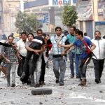 Un policía egipcio golpea a un grupo de seguidores de Mursi, en la Plaza Ramsés, en El Cairo
