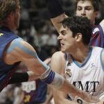 El alero del Real Madrid Carlos Suarez lucha con el ala pivot norteamericano del Barcelona Regal, C.J. Wallace, durante el primer partido de la final de la Liga Endesa de Baloncesto disputado esta mañana en el Palacio de los Deportes de la capital.