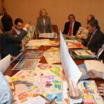 Panorámica de la mesa de selección de trabajos de los miembros del Jurado Internacional Paz y Cooperación, al fondo, de pie la presidente doña Carmen de Alvear, exponiendo los trabajos premiados, a la derecha, sentado, don Joaquín Antuña, presidente y fundador de Paz y Cooperación.