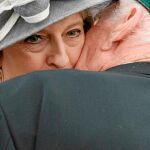 Un veterano del desembarco de Normandía besa ayer a la todavía «premier» británica, Theresa May