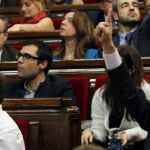 Los presidentes de los grupos parlamentarios de CiU, Jordi Turull (d) y de ERC, Oriol Junqueras (i) dan instrucciones de voto afirmativo.