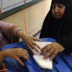 Una mujer iraquí deposita su papeleta para las elecciones parlamentarias en un centro electoral en Bagdad.