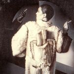 Este espectacular diseño en macramé pertenece a la colección de invierno de 1981. Lola Sordo, una popular modelo de la época, posa para Javier Valhonrat, mientras la silueta de Manuel Piña emerge entre las sombras