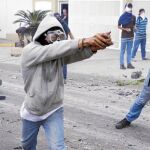 Un grupo de estudiantes se enfrenta, ayer, con piedras a la Policía durante una protesta en San Cristóbal