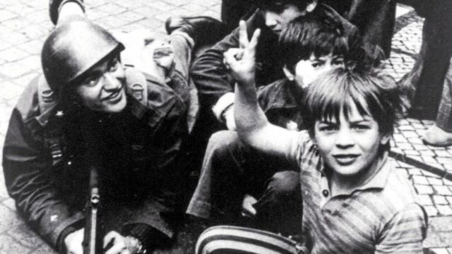 Como un milagro descansaban los fusiles a los pies de los niños que hacían la señal de la victoria con un manojo invisible de sueños entre los dedo