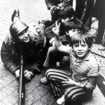 Como un milagro descansaban los fusiles a los pies de los niños que hacían la señal de la victoria con un manojo invisible de sueños entre los dedo
