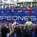 Los jugadores del Atlético de Madrid en el autocar que les traslada desde el estadio Vicente Calderón de Madrid hasta la fuente de Neptuno, en la plaza de Cánovas del Castillo de Madrid, donde miles de aficionados les esperan para celebrar el título de La Liga que lograron ayer tras vencer al FC Barcelona.