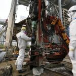 Varios trabajadores construyen un muro de hielo para congelar el agua radiactiva en la planta nuclear de Fukushima.