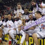 Los jugadores del Real Madrid posan con el trofeo tras conseguir hoy la vigésimo quinta Copa del Rey de baloncesto.