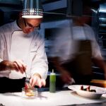 Un cocinero monta un plato en un restaurante