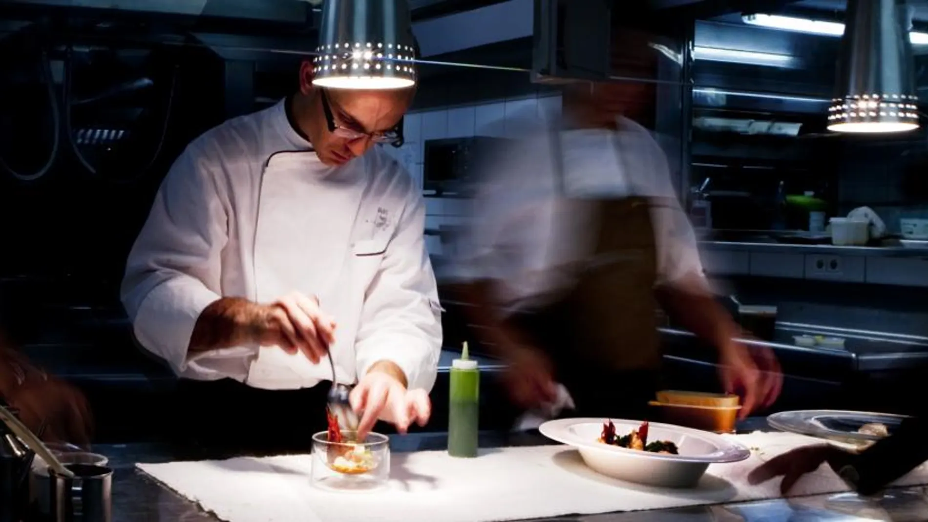 Un cocinero monta un plato en un restaurante