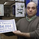 El responsable de la administración número 15, situada en el centro Comercial El Val, de Alcalá de Henares (Madrid), muestra el número 64.084, que ha sido agraciado con el tercer premio del Sorteo Extraordinario de la Lotería de Navidad