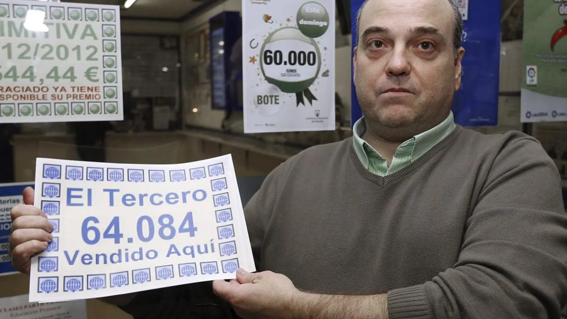 El responsable de la administración número 15, situada en el centro Comercial El Val, de Alcalá de Henares (Madrid), muestra el número 64.084, que ha sido agraciado con el tercer premio del Sorteo Extraordinario de la Lotería de Navidad