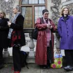 Varias pastoras anglicanas esperan en la puerta de la sede de la Iglesia anglicana, en Londres.