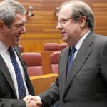 Juan Vicente Herrera y Julio Villarrubia se estrechan la mano, en el marco del hemiciclo de las Cortes de Castilla y León