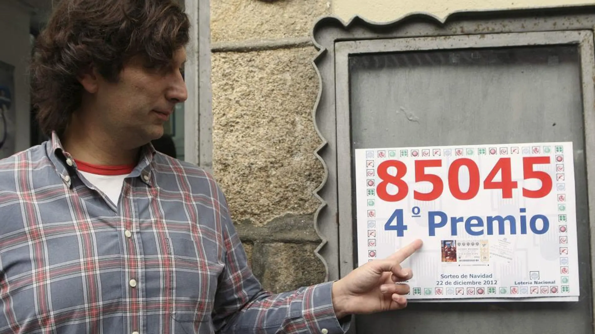 Juan Ignacio Molina, dueño de la Administración de lotería número 5 de Pontevedra, donde ha vendido a la mutualista AMA, mutua de los profesionales sanitarios, un cuarto premio íntegro del Sorteo Extraordinario de Navidad, muestra el número agraciado 85045
