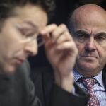 El ministro de Economía español, Luis de Guindos (d), observa a su homólogo holandés, Jeroen Dijsselbloem.