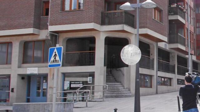 Un cámara aguarda a las puertas del domicilio de Bolinaga en Mondragón, junto al vehículo de la Ertzaintza