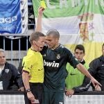 GRA373. MÁLAGA, 22/12/2012.- El colegiado Hernández Hernández (i), muestra tarjeta amarilla al defensa portugués del Real Madrid, Pepe, durante el encuentro correspondiente a la decimoséptima jornada de primera división, que han disputado esta noche frente al Málaga en el estadio La Rosaleda de la capital andaluza. EFE/Daniel Pérez.