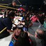 El luchador recibiendo atención médica tras recibir una patada de su rival.