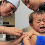 Un niño llora al recibir una vacuna en Mongolia