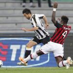 Giampiero Pazzini, del Udinese, supera a Sullay Muntari, del Milan, durante el partido de hoy en Udine.