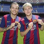 Fotografía cedida por el FC Barcelona de Louis Tomlinson (i) y el guitarrista irlandés Niall Horan (d), miembros del grupo musical One Direction, quienes posan con las camisetas del FC Barcelona durante su visita hoy al Camp Nou