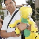 El venezolano Daniel Castro junto a una joven con el peluche que el hijo de Castro, Carlos de 7 años perdió en el descarrilamiento del tren Alvia, tras encontrarlo en el pabellón que la Policía ha habilitado para recuperar los equipajes y efectos personales de las víctimas