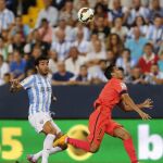 El defensa del Málaga CF, Miguel Torres (i), lucha el balón con el delantero del FC Barcelona, Pedro Rodríguez, durante el encuentro de la quinta jornada de Liga en Primera División que se disputa esta noche en el estadio de La Rosaleda, en Málaga